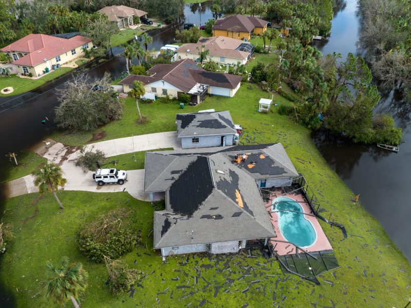 Destroyed house roof by hurricane Ian strong winds in Florida residential area. Natural disaster and its consequences.